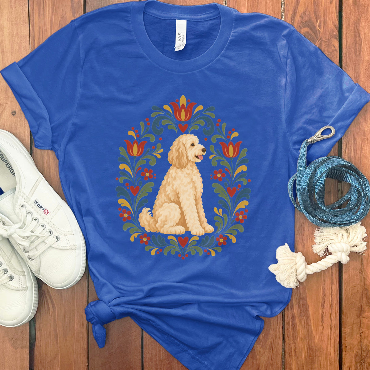 Royal blue t-shirt with a cream doodle dog in a floral wreath design.