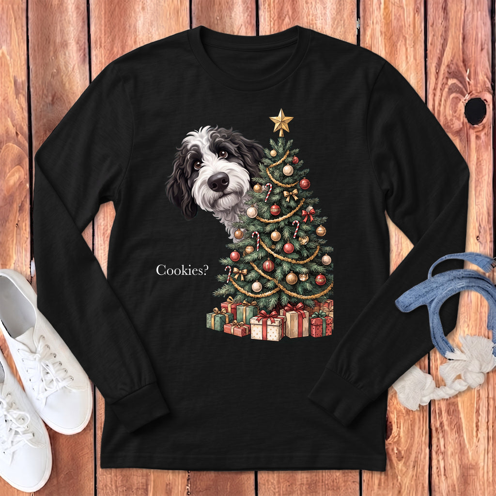 Black long-sleeve shirt with a black and white dog peeking by a decorated Christmas tree and presents.