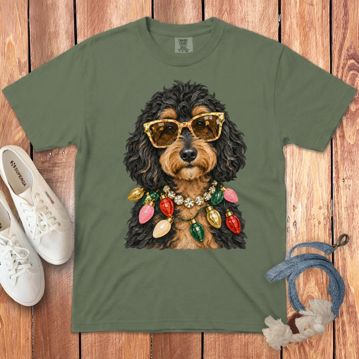 Dog with sunglasses and Christmas lights necklace on green t-shirt.