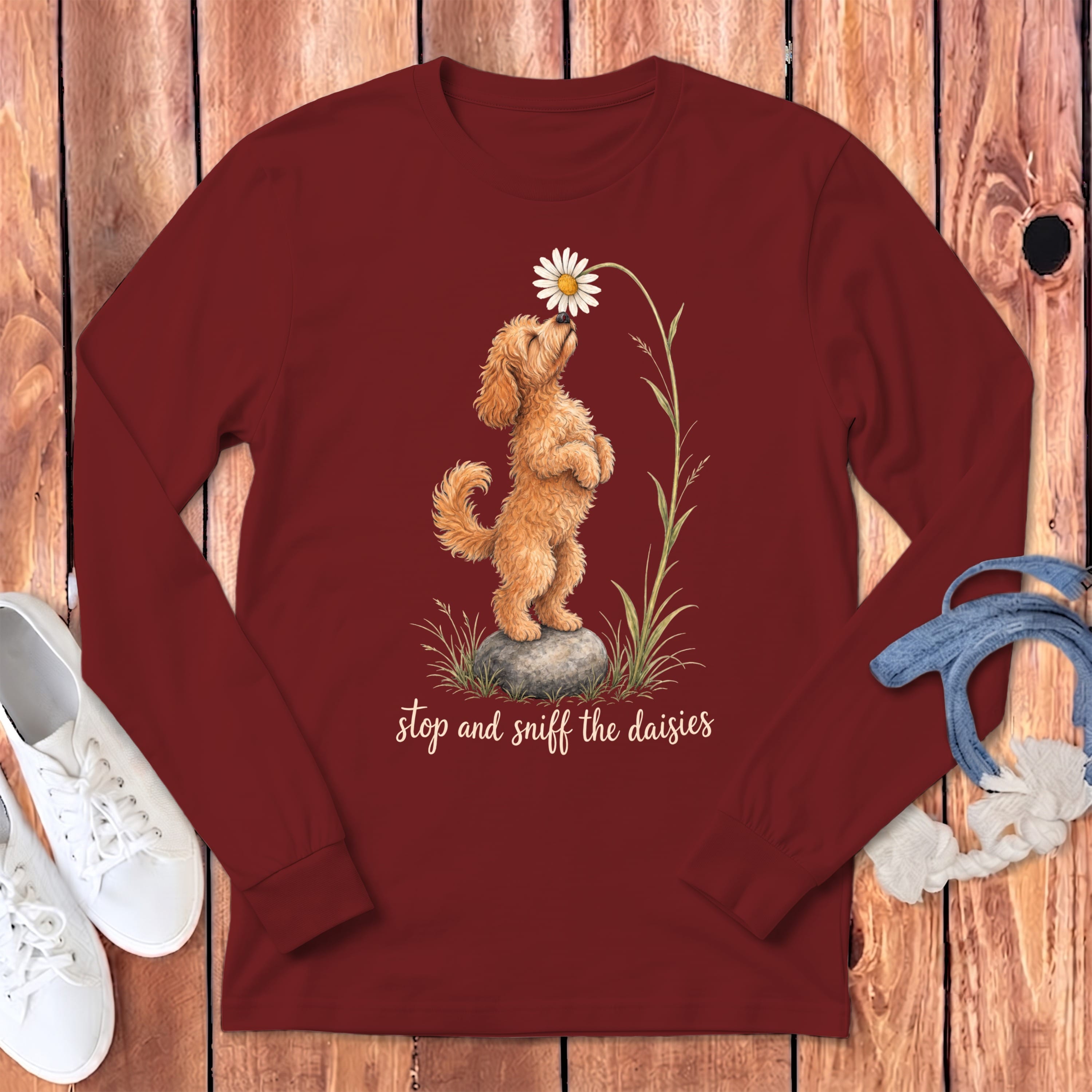 Maroon long-sleeve shirt with dog sniffing daisy graphic and text "stop and sniff the daisies".