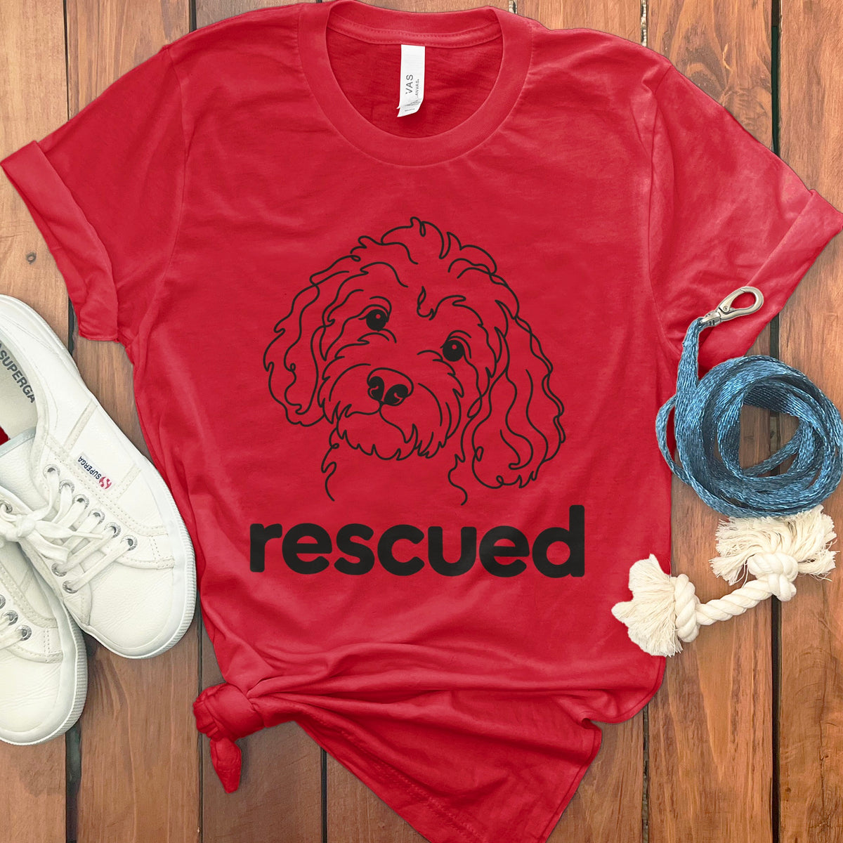 Red t-shirt with a black line drawing of a dog and the word "rescued".