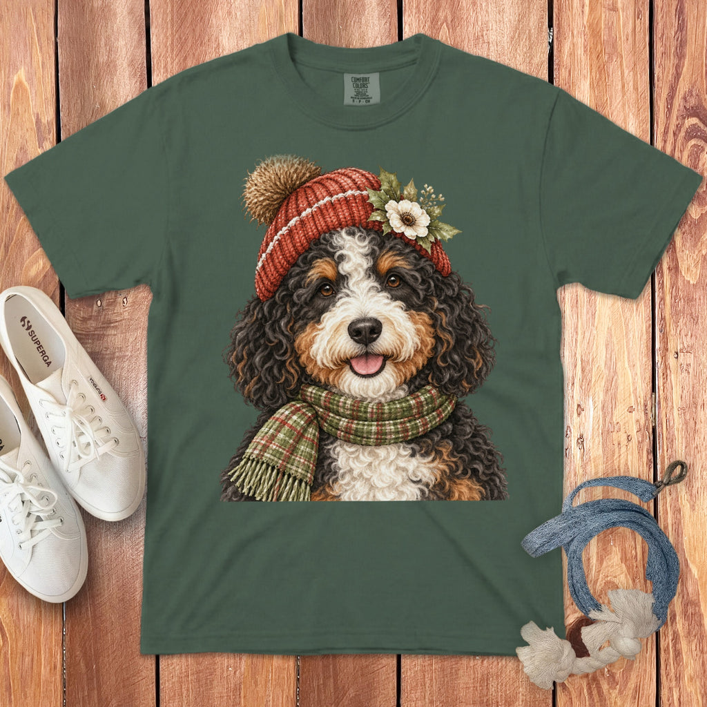 Green t-shirt with a Bernese Mountain Dog wearing a red beanie and plaid scarf.