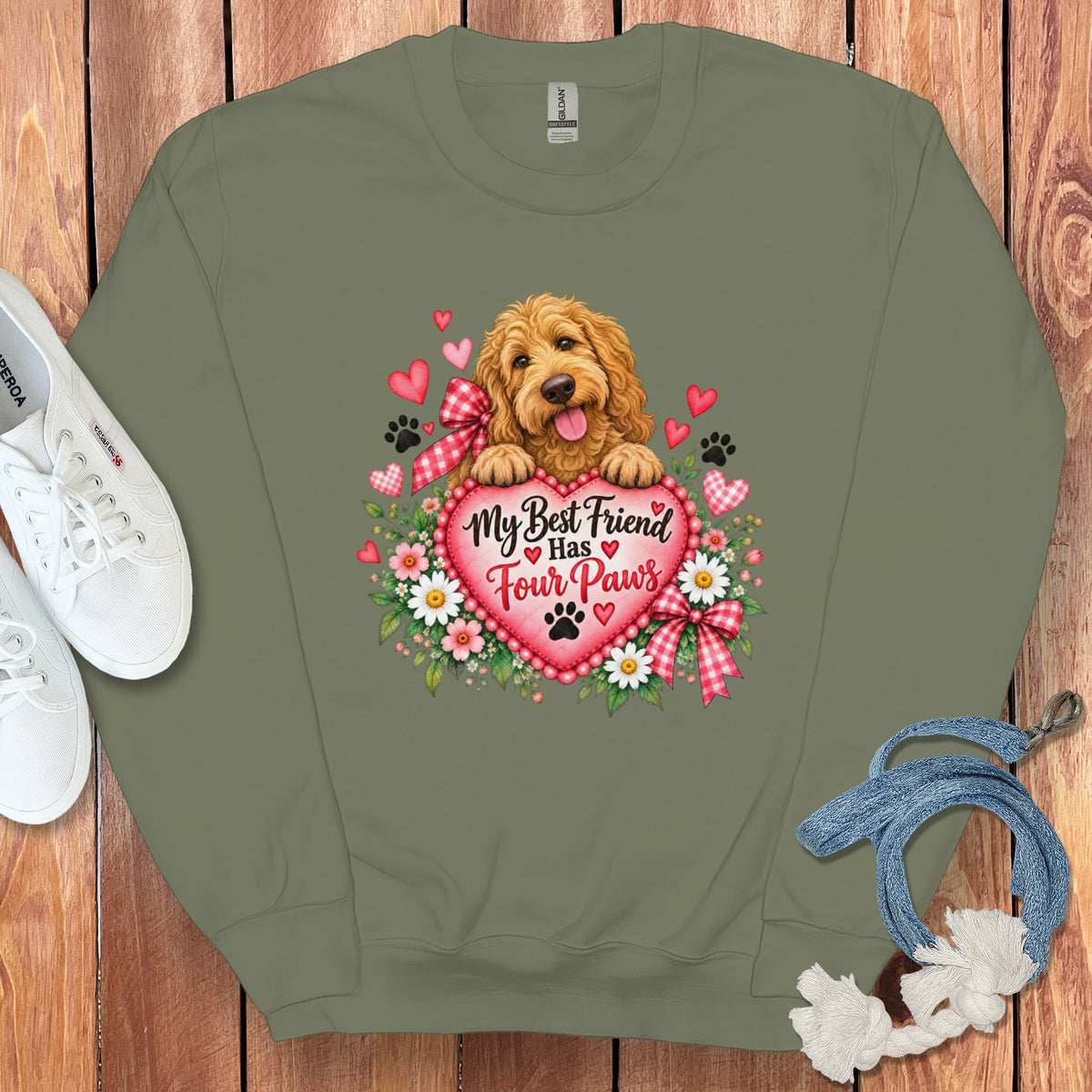 An olive green sweatshirt featuring a fluffy golden dog behind a pink heart with the text "My Best Friend Has Four Paws".