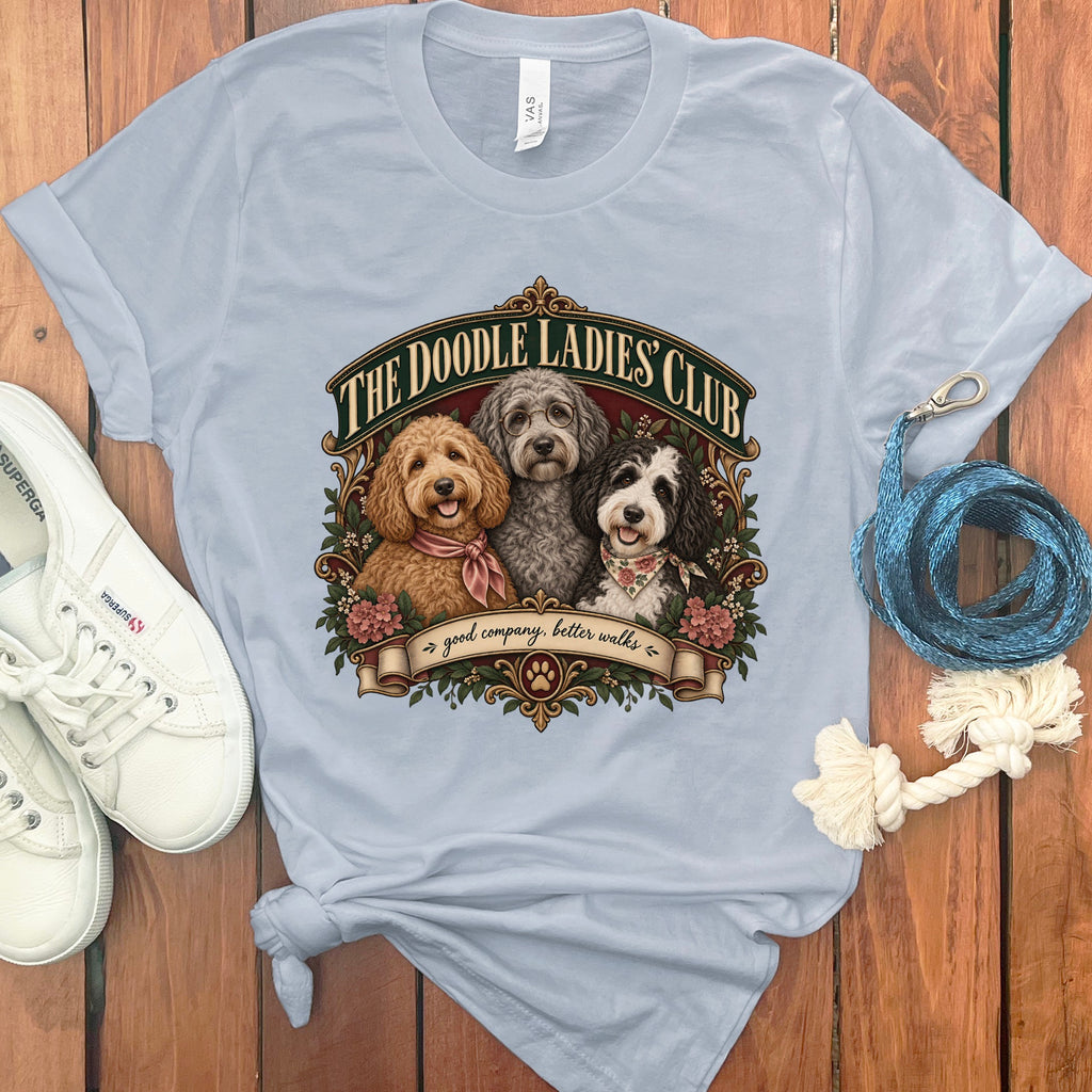 Light blue t-shirt with three doodles and "The Doodle Ladies Club" text.