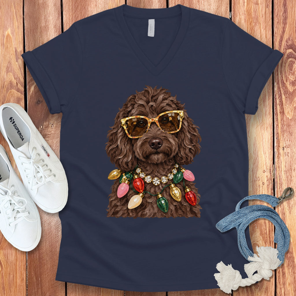 Brown doodle dog wearing sunglasses and colorful Christmas lights necklace on navy shirt.