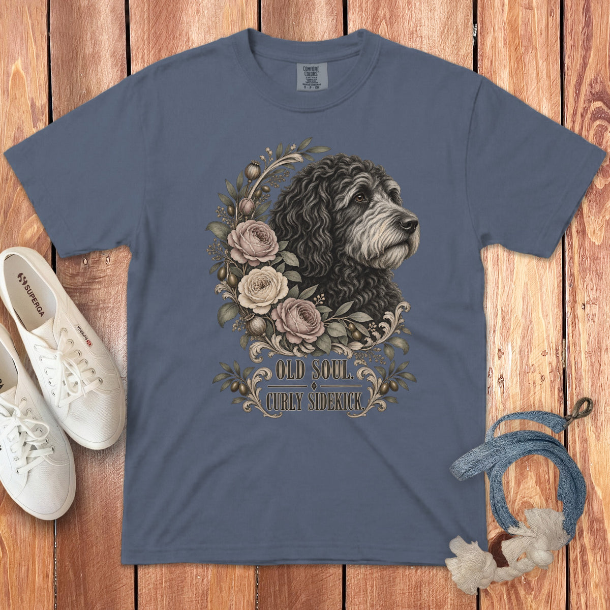 Slate blue t-shirt featuring a curly-haired dog illustration surrounded by roses, with the text Old Soul Curly Sidekick.