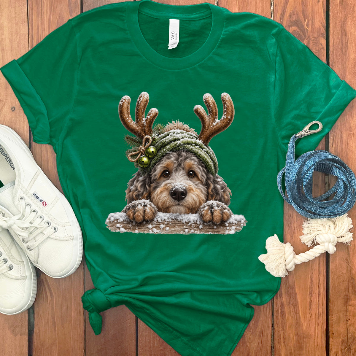 Green t-shirt with a festive doodle dog wearing antlers and a knit hat.