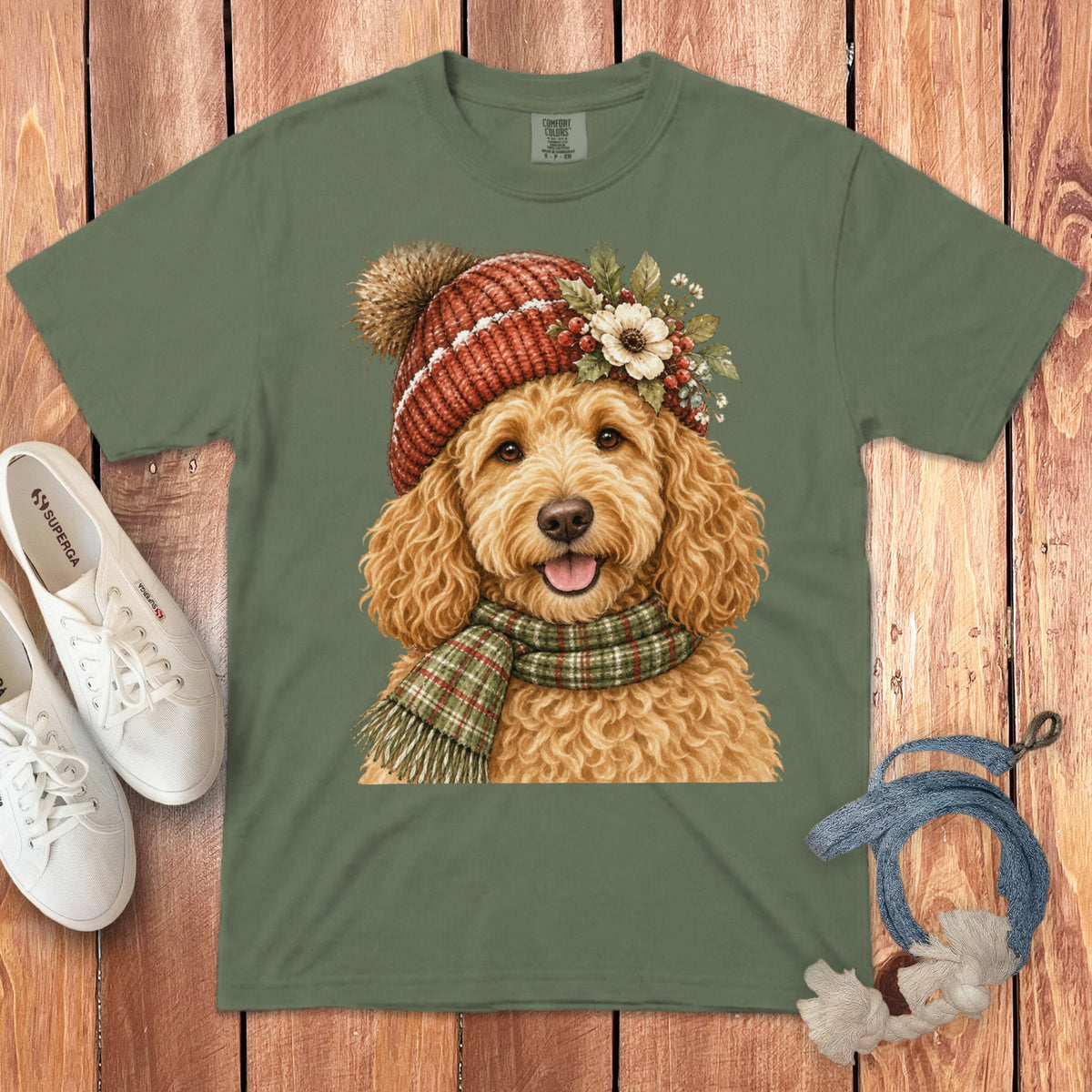 Green t-shirt with watercolor painting of a fluffy dog wearing a hat and scarf.