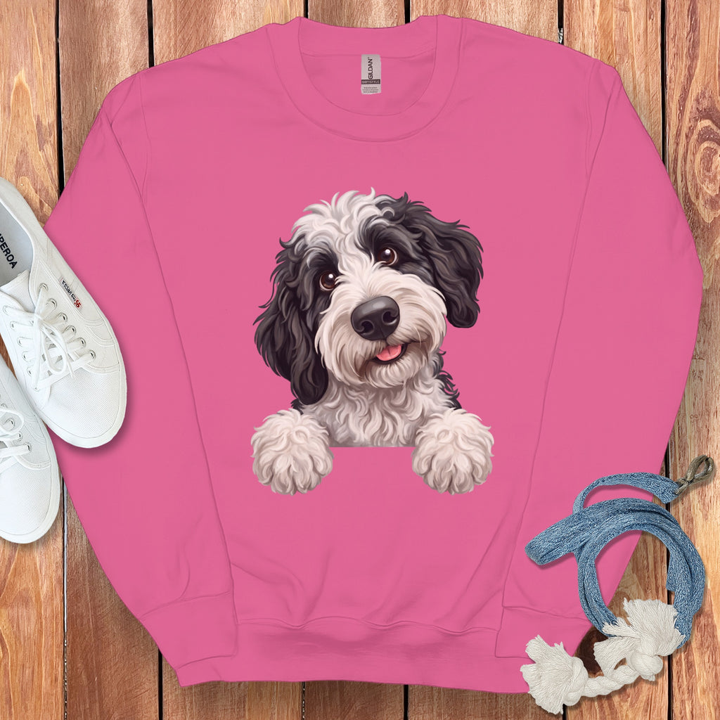 Pink sweatshirt with a black and white fluffy dog graphic peeking over the front.