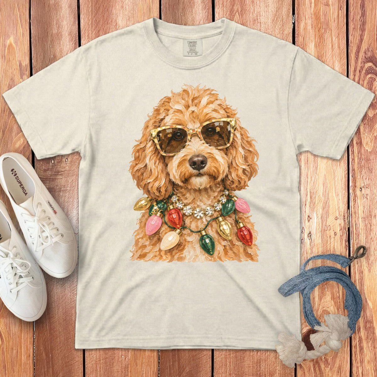 Cream t-shirt with fluffy dog wearing sunglasses and string lights necklace.