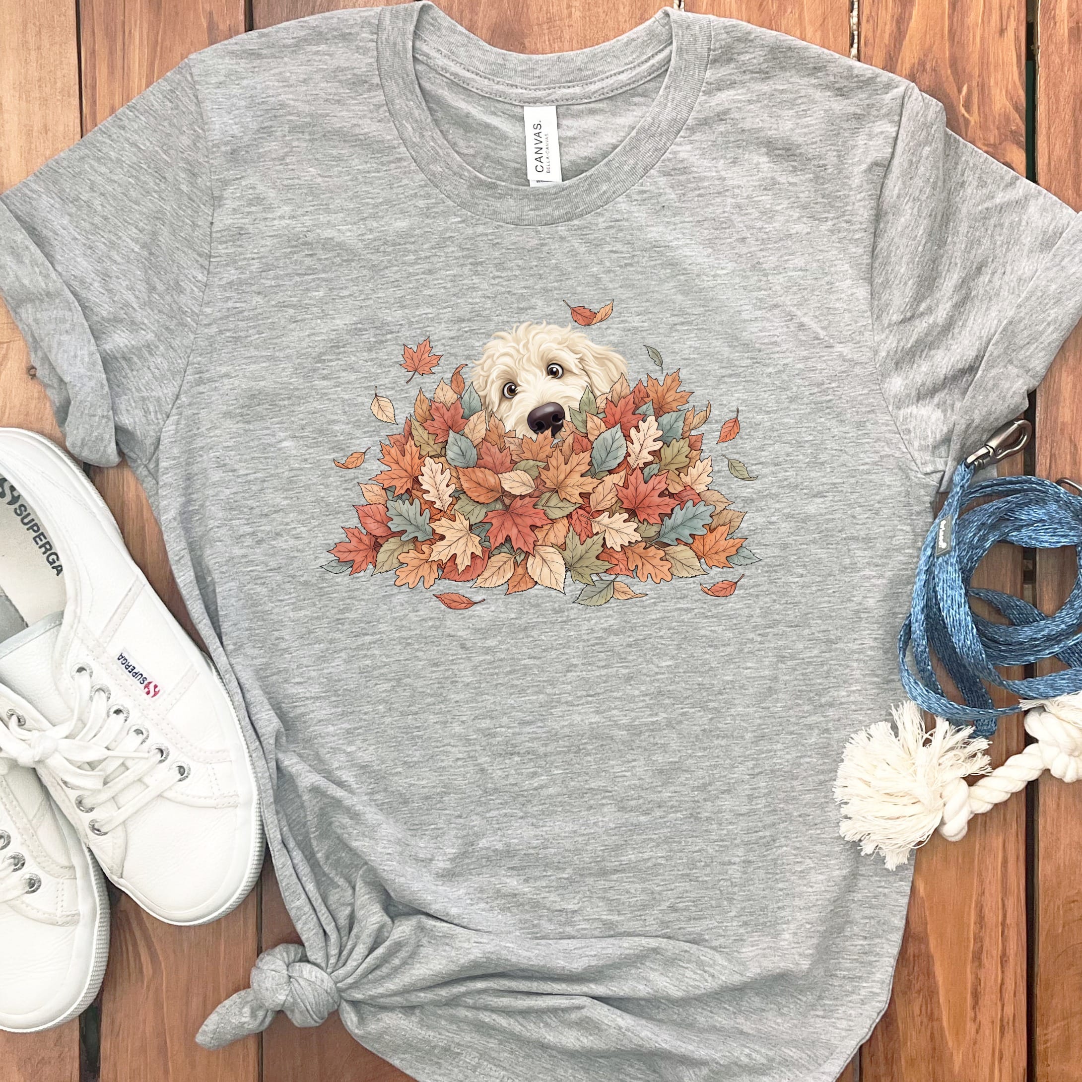 Cream Goldendoodle Peeking Leaf Pile T-Shirt in Athletic Heather / S by Puppy Jo