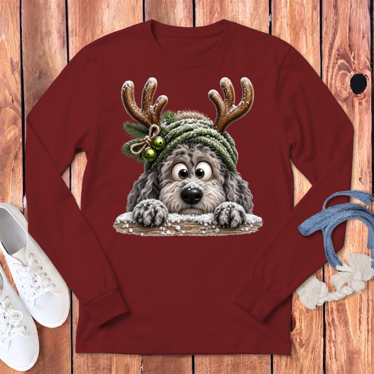 Maroon long-sleeve shirt with a fluffy dog wearing reindeer antlers and a snow-covered hat.