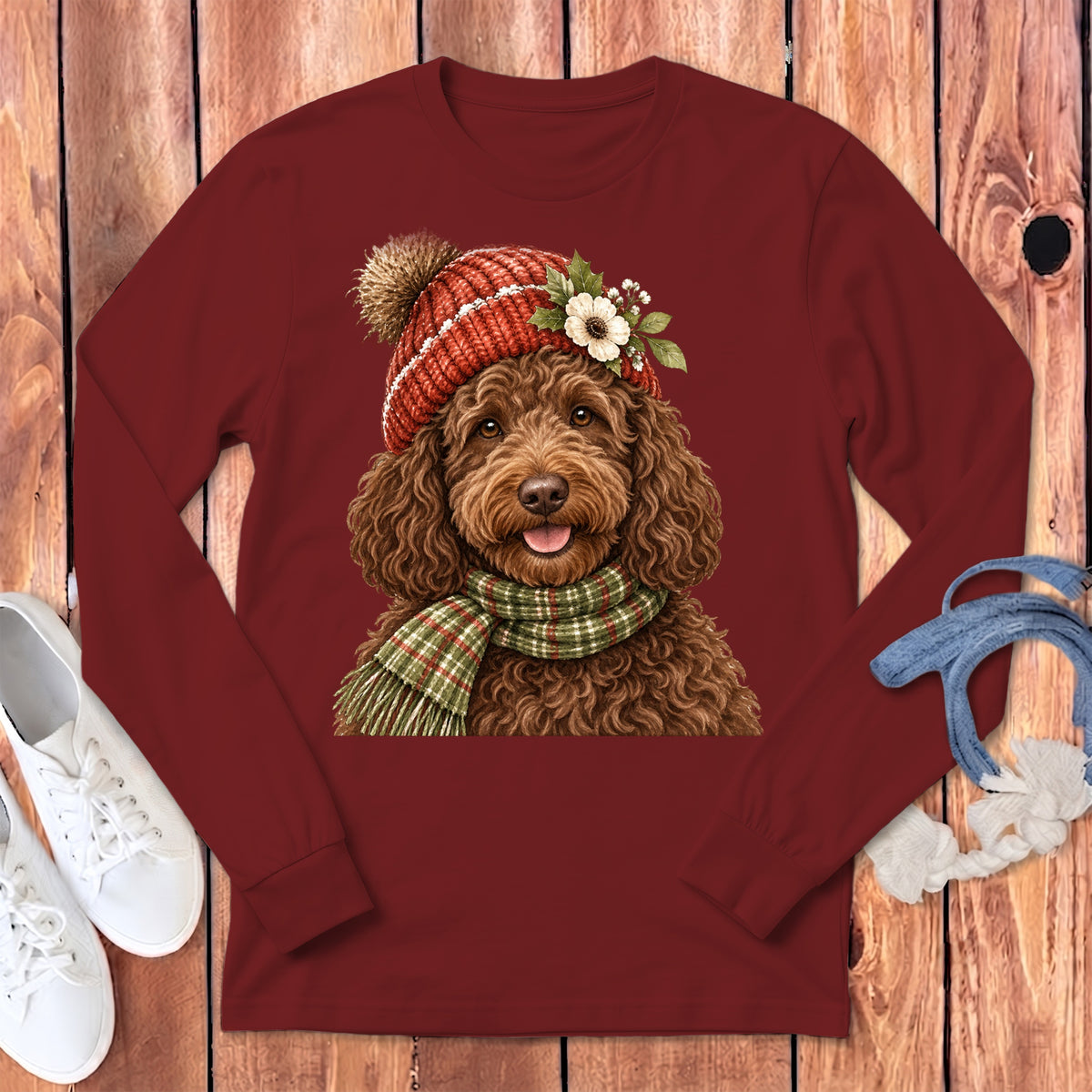 Brown dog wearing a knitted hat and scarf, printed on a maroon long-sleeve shirt.