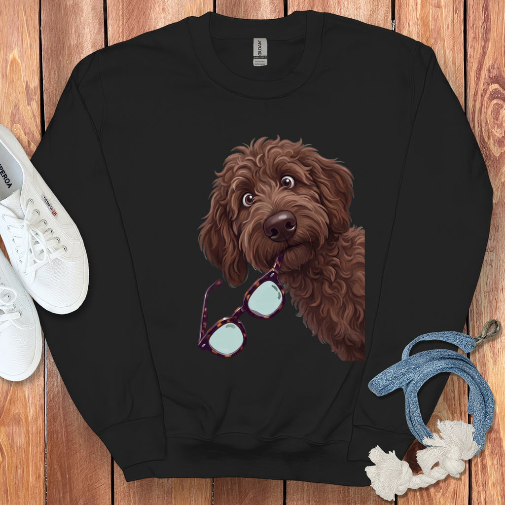 Black crewneck sweatshirt featuring a graphic of a brown curly dog holding glasses in its mouth.