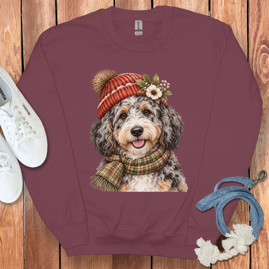 Maroon sweatshirt with watercolor print of a Bernedoodle wearing a knit hat and scarf.