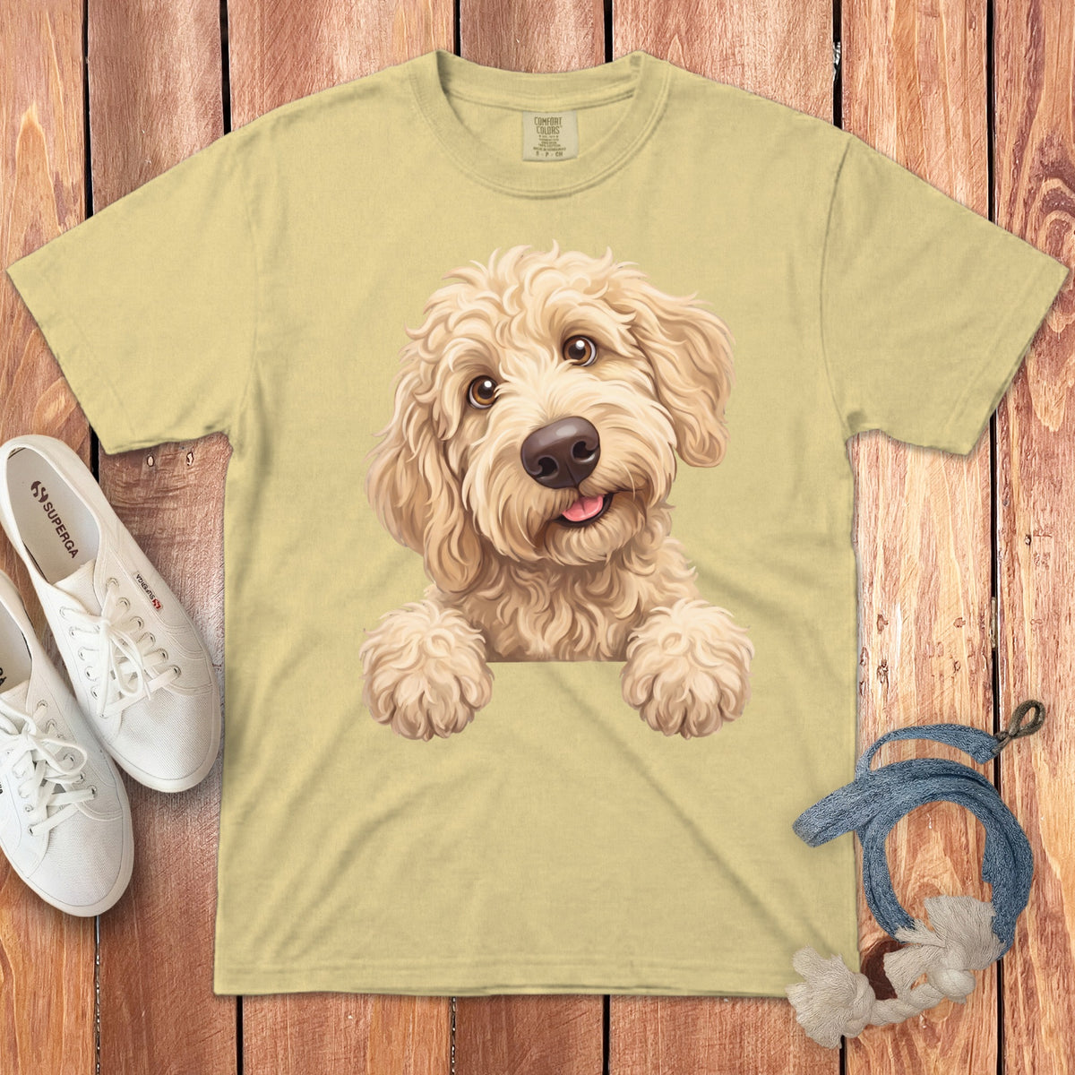 Light yellow t-shirt with a cartoon doodle dog print, sneakers, and dog toy.