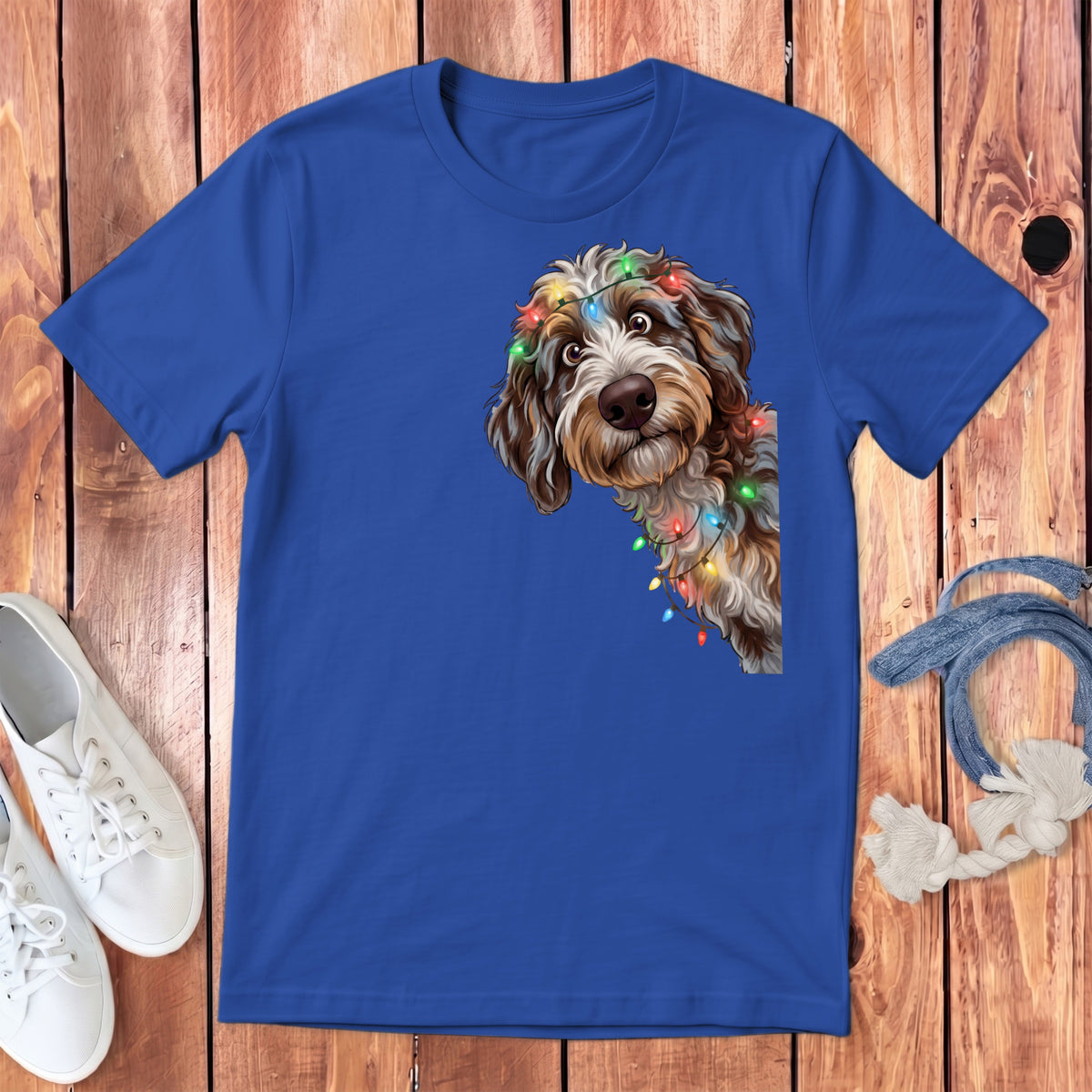 Dog with Christmas lights on blue t-shirt with white sneakers and rope.