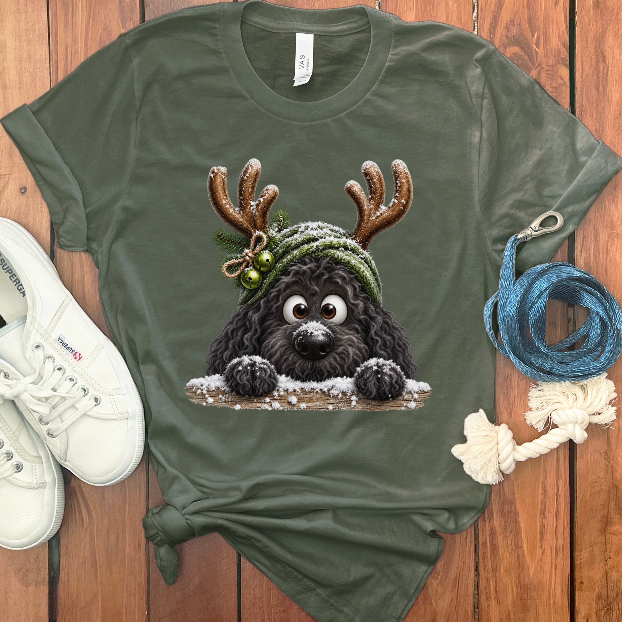 Green t-shirt with cartoon black dog wearing reindeer antlers and a hat with bells.