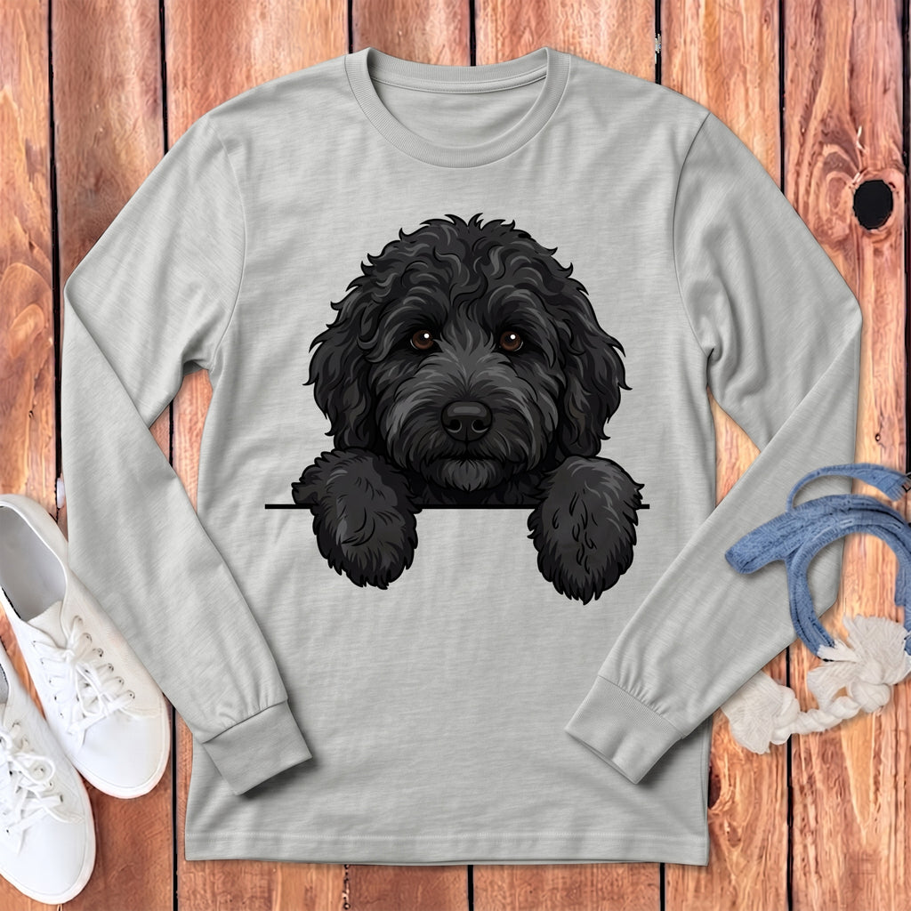 Black poodle with paws over a black line on a light gray long-sleeve shirt.