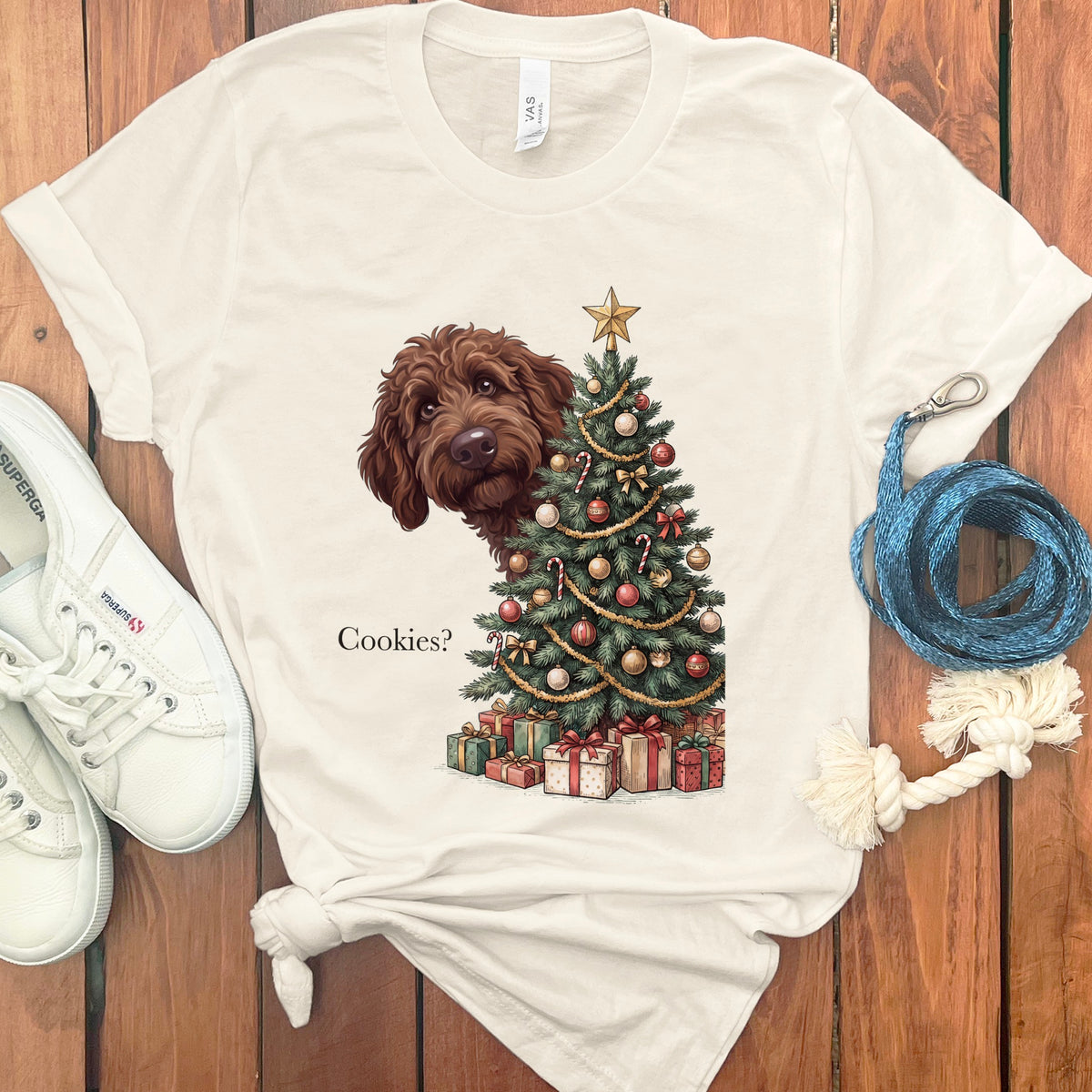 Brown dog peeking from behind Christmas tree with gifts and text "Cookies?".