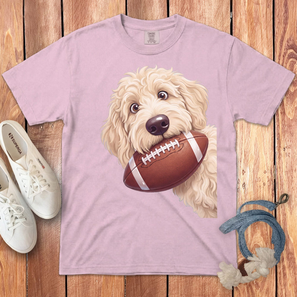 Light pink t-shirt with doodle dog graphic holding a football.