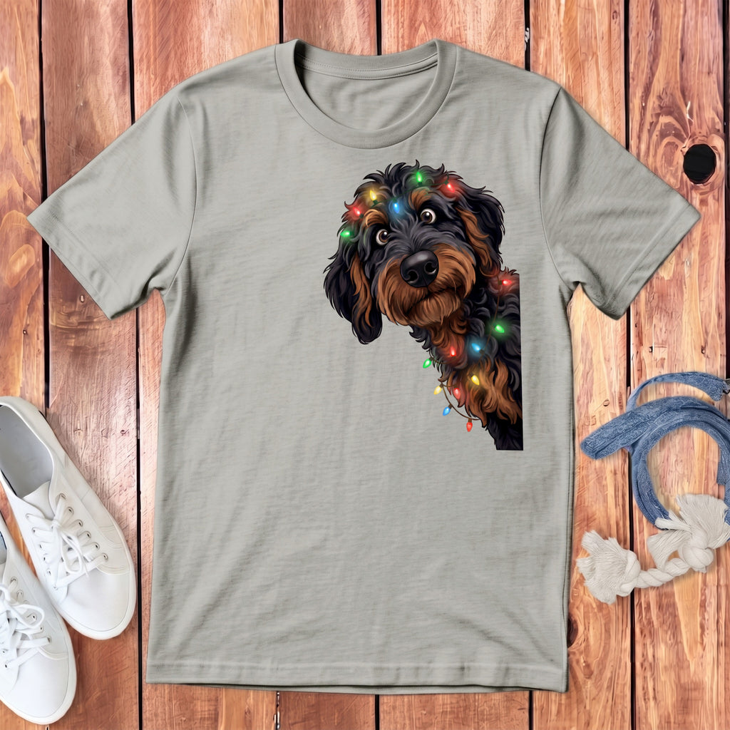 Light grey t-shirt with graphic of a fluffy dog wearing colorful Christmas lights.