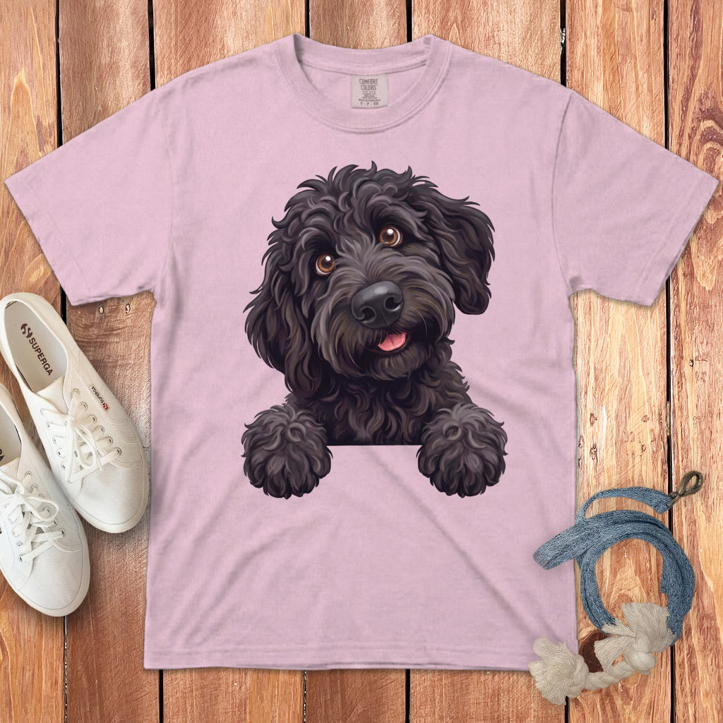 Pink t-shirt with a drawing of a black doodle dog peeking over a white border.