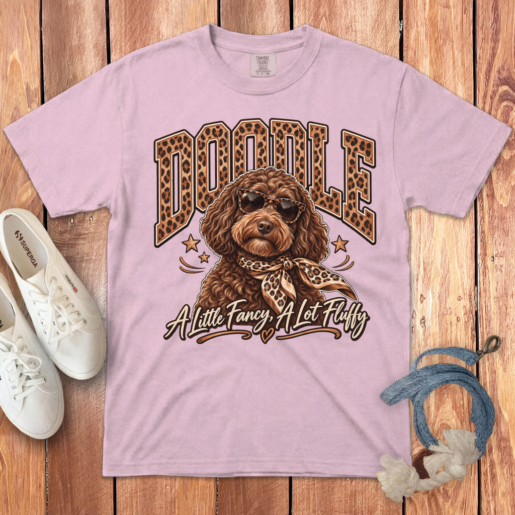 Pink t-shirt with "DOODLE" in leopard print, a dog wearing sunglasses and scarf, and text "A little Fancy, A Lot Fluffy".