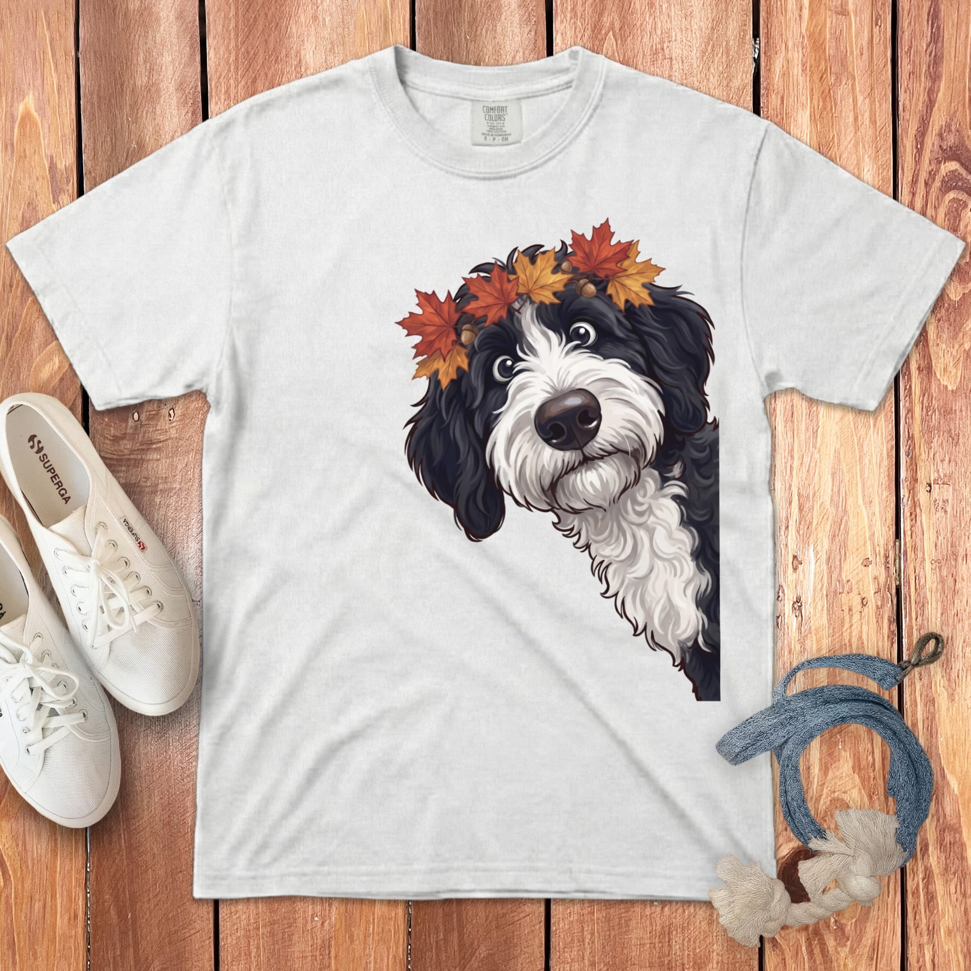 White t-shirt with a black and white dog wearing a fall leaf crown graphic.