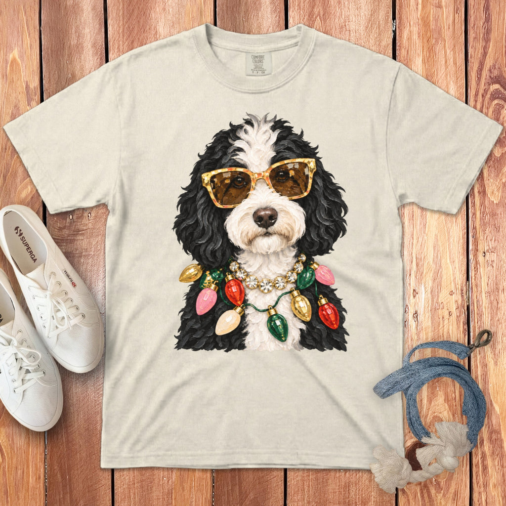Cream t-shirt with a black and white dog wearing sunglasses and a Christmas light necklace.