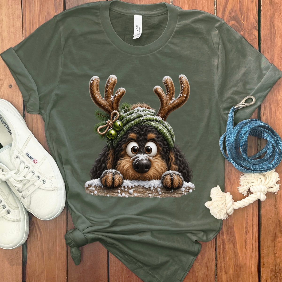 Green t-shirt featuring a cartoon dog with reindeer antlers and a green knit hat.