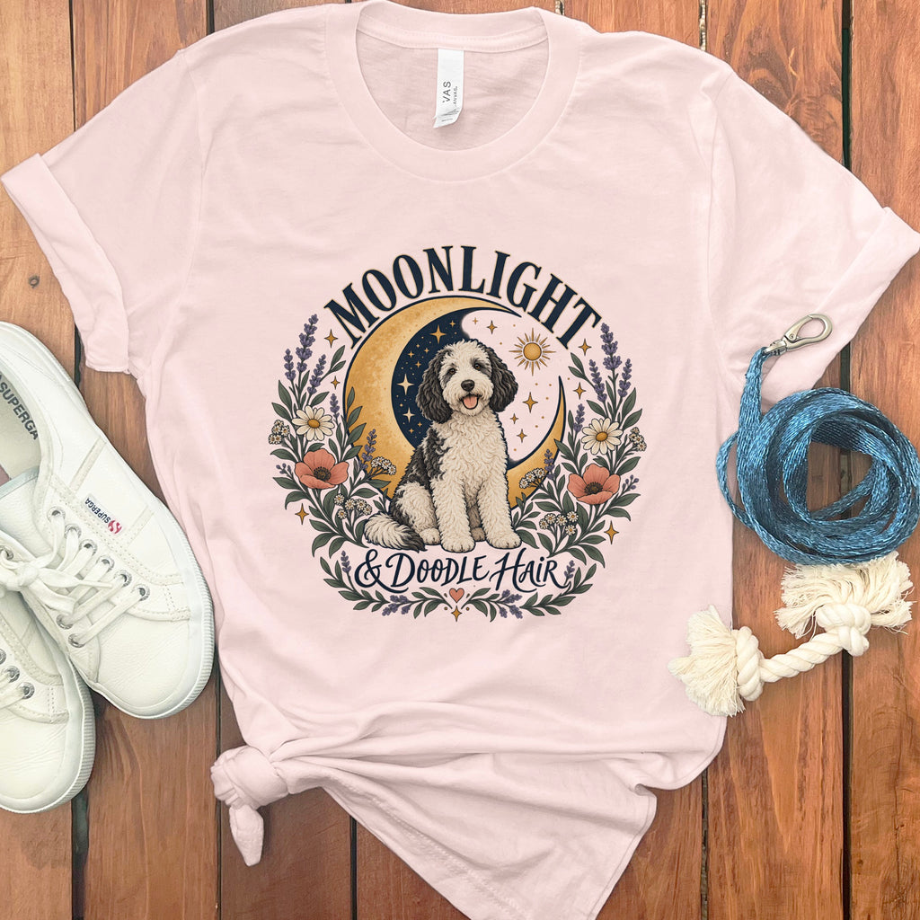 Pink t-shirt with a doodle dog, crescent moon, and text "Moonlight & Doodle Hair".
