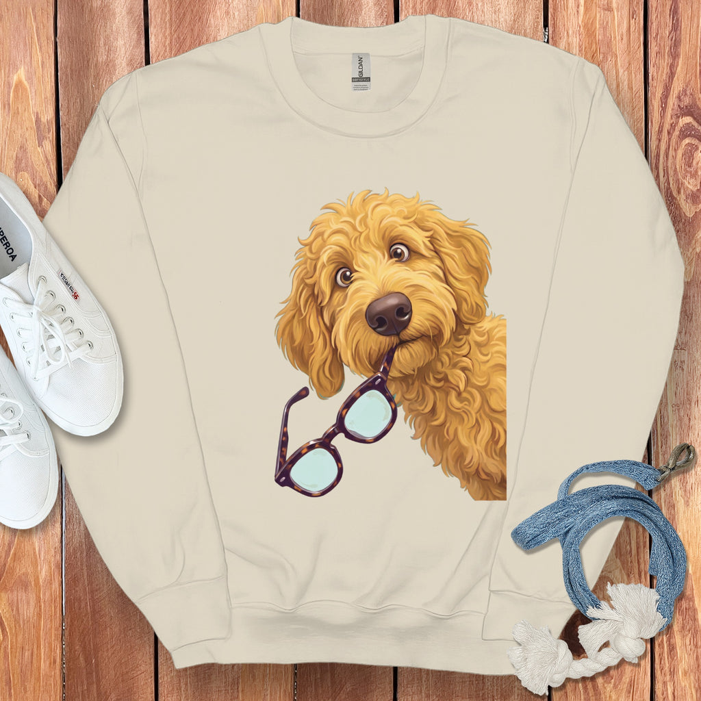 Cream crewneck sweatshirt featuring a graphic of a golden doodle dog holding tortoiseshell glasses.