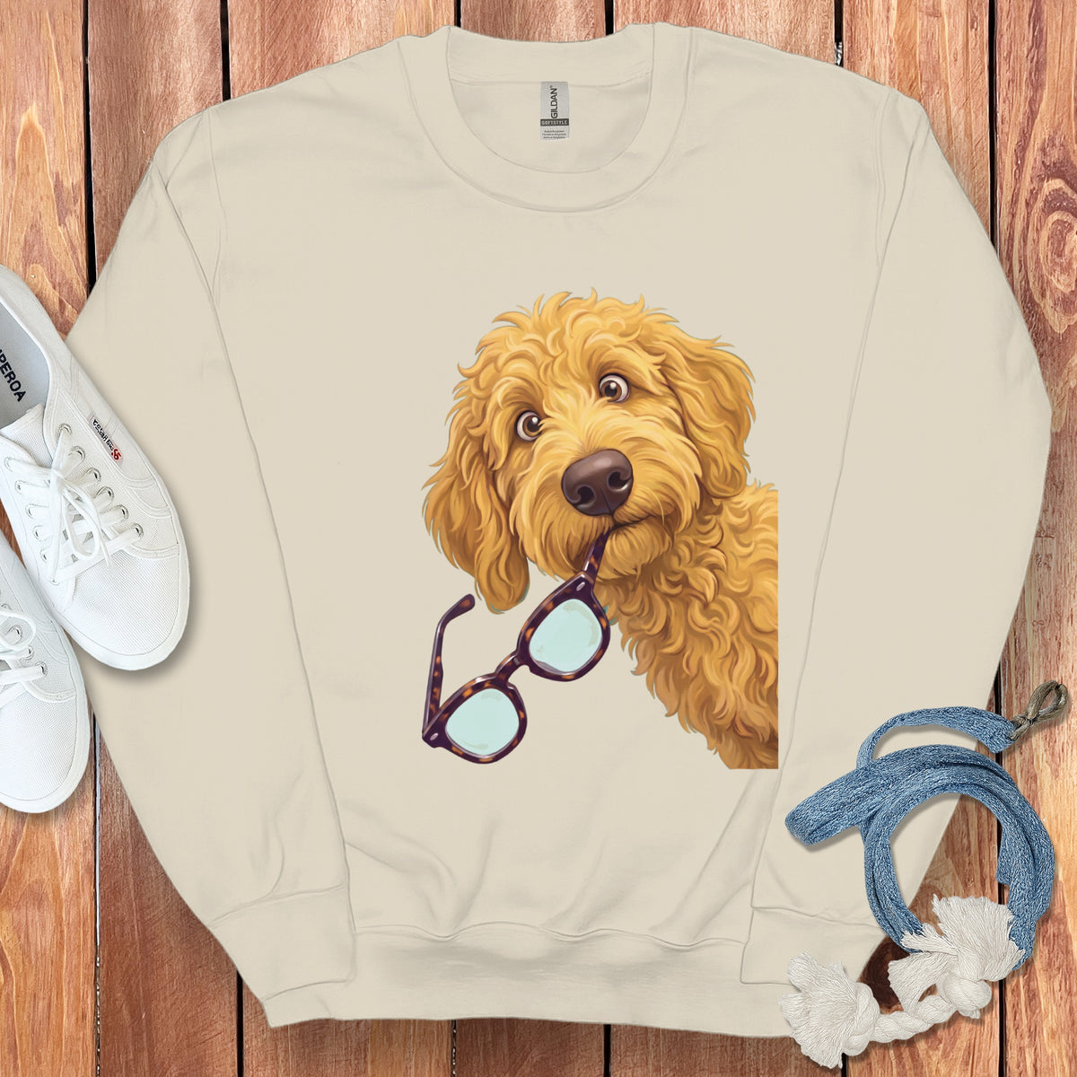 Cream crewneck sweatshirt featuring a graphic of a golden doodle dog holding tortoiseshell glasses.