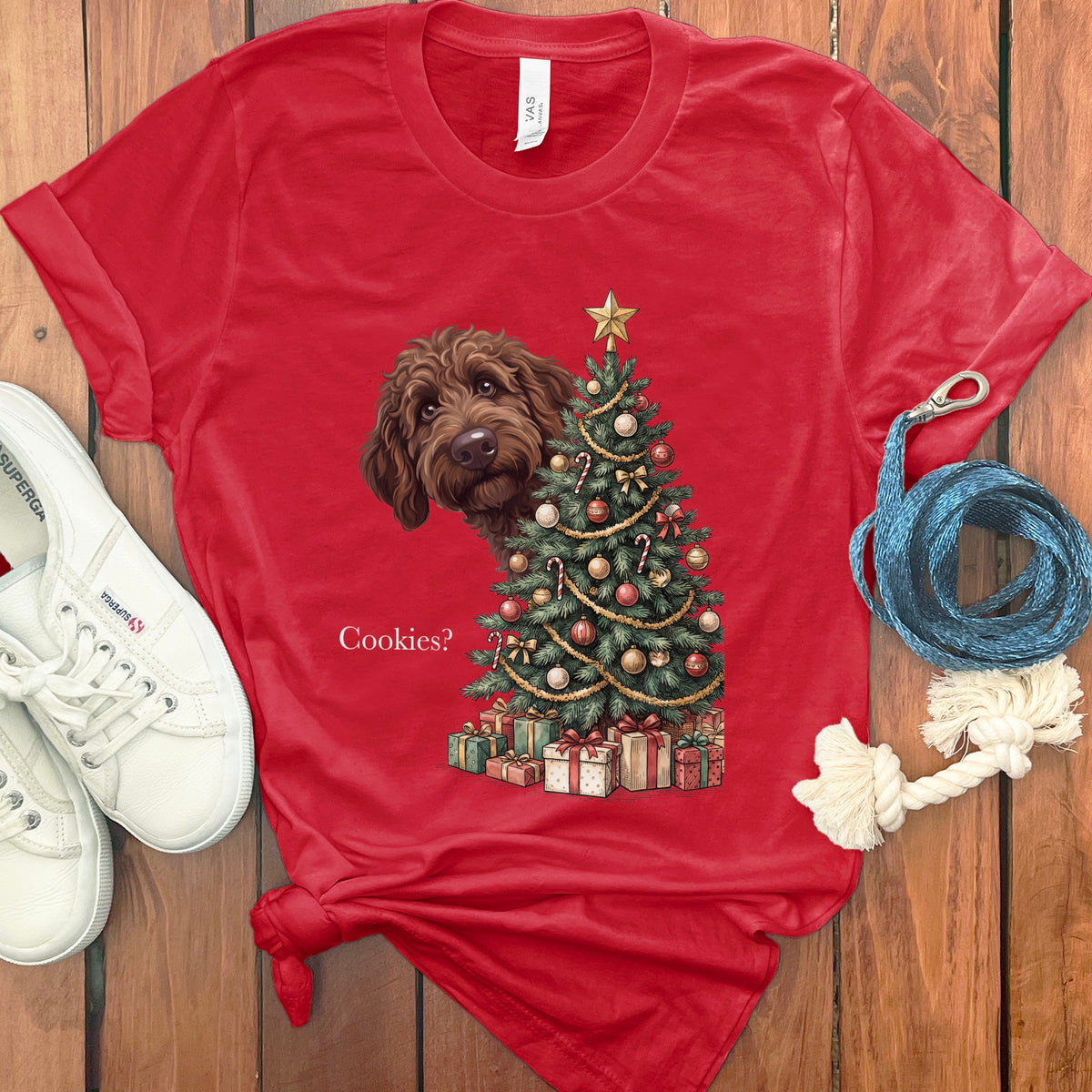 Brown dog peeking beside a decorated Christmas tree with gifts and the text "Cookies?".