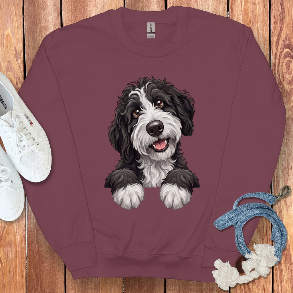 Burgundy crewneck sweatshirt with a black and white fluffy dog illustration.