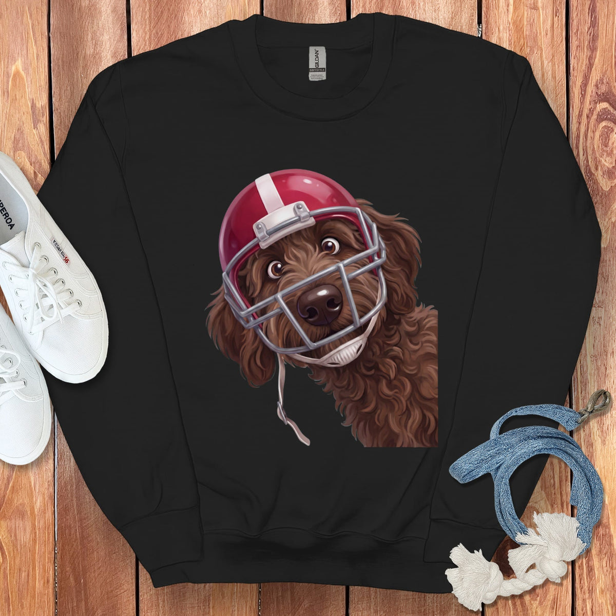 Brown doodle dog wearing a red football helmet on a black sweatshirt.