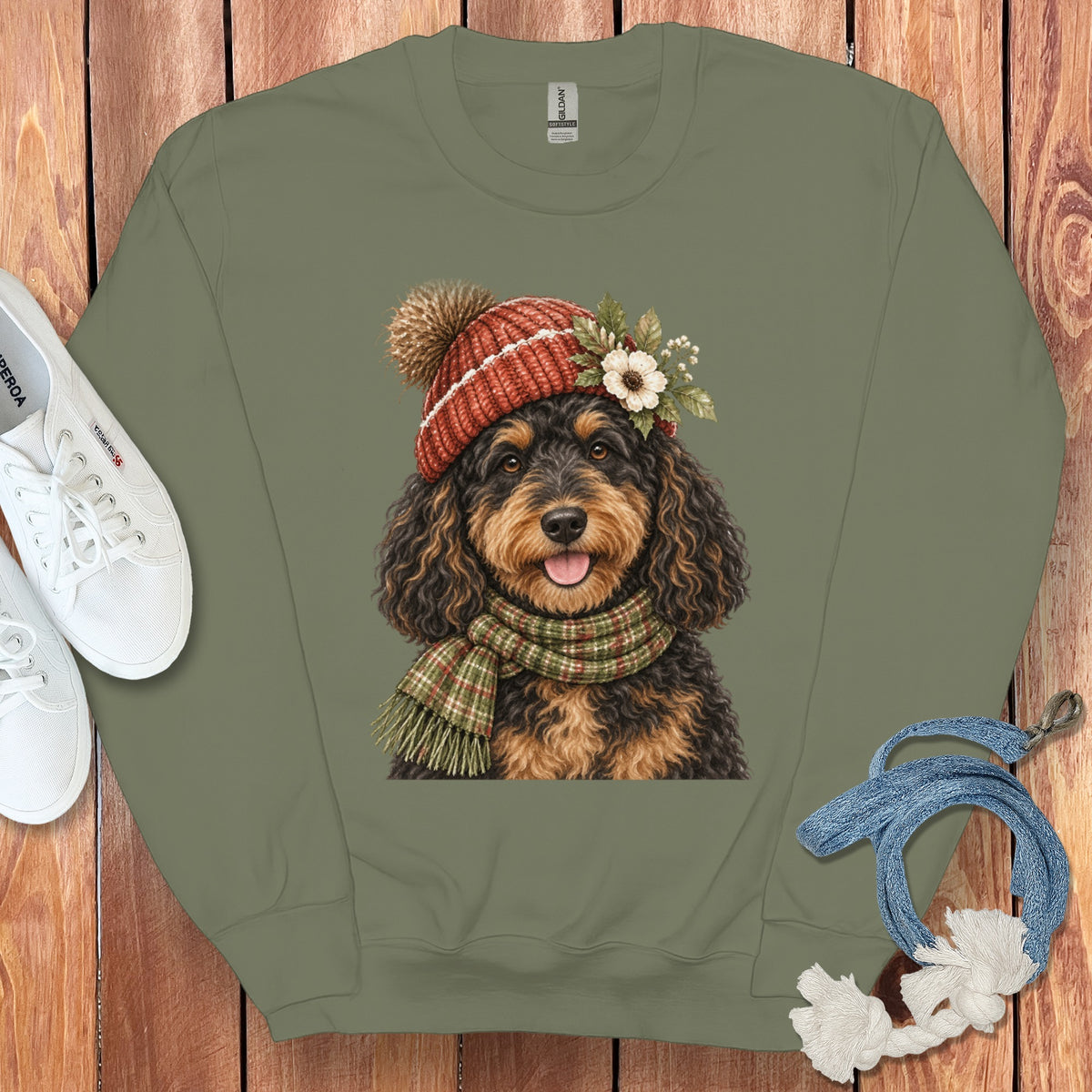 Olive green sweatshirt with a watercolor doodle dog wearing a pom-pom hat and scarf.