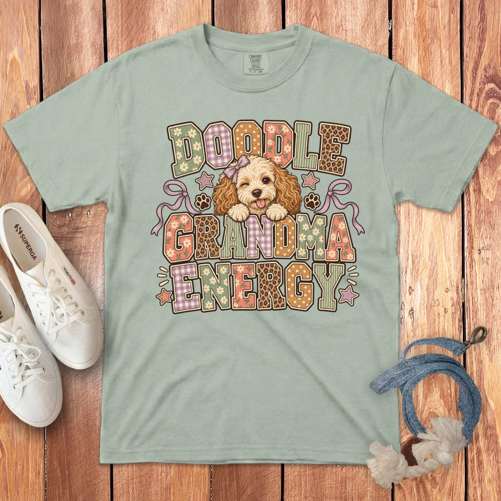 Sage green t-shirt with a Doodle Grandma Energy graphic featuring an illustrated dog on a wooden background.