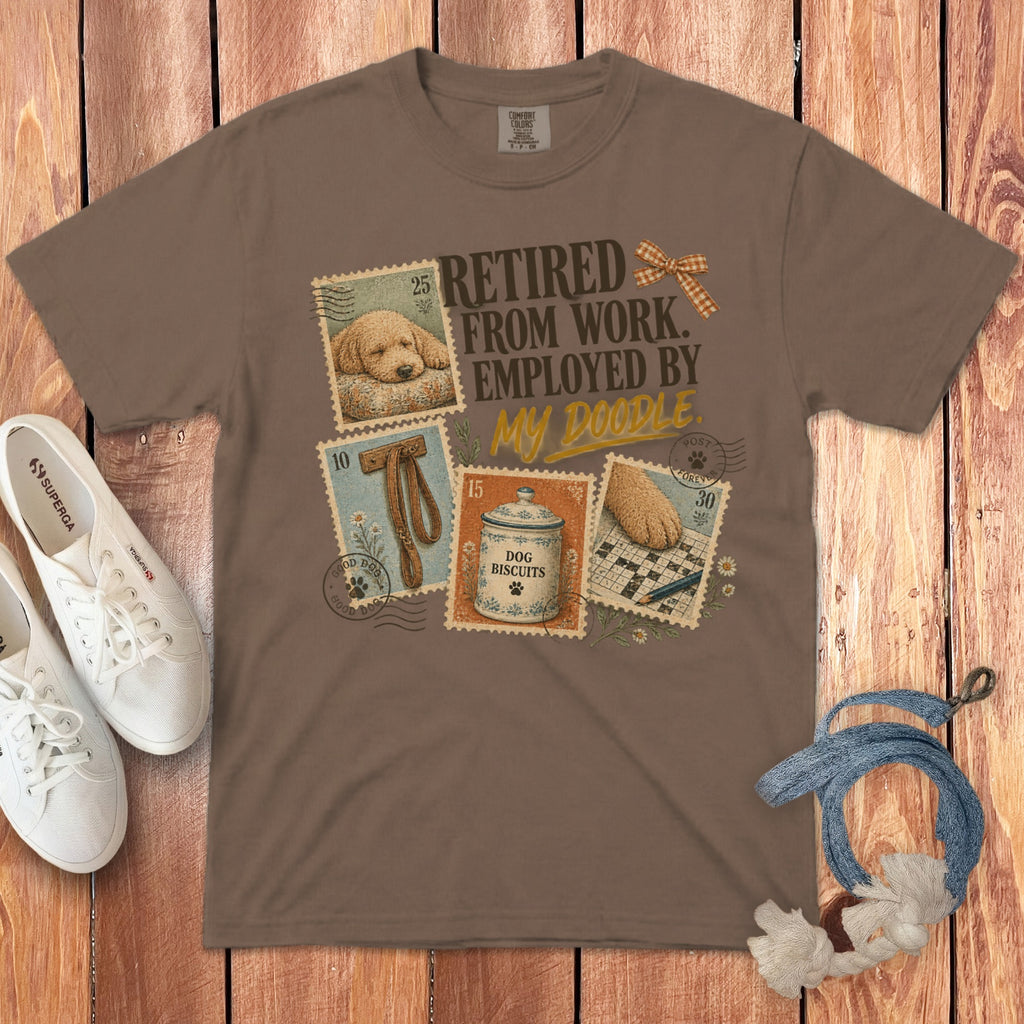 Brown t-shirt featuring vintage postage stamps with dog-themed illustrations and text reading Retired From Work Employed By My Doodle.
