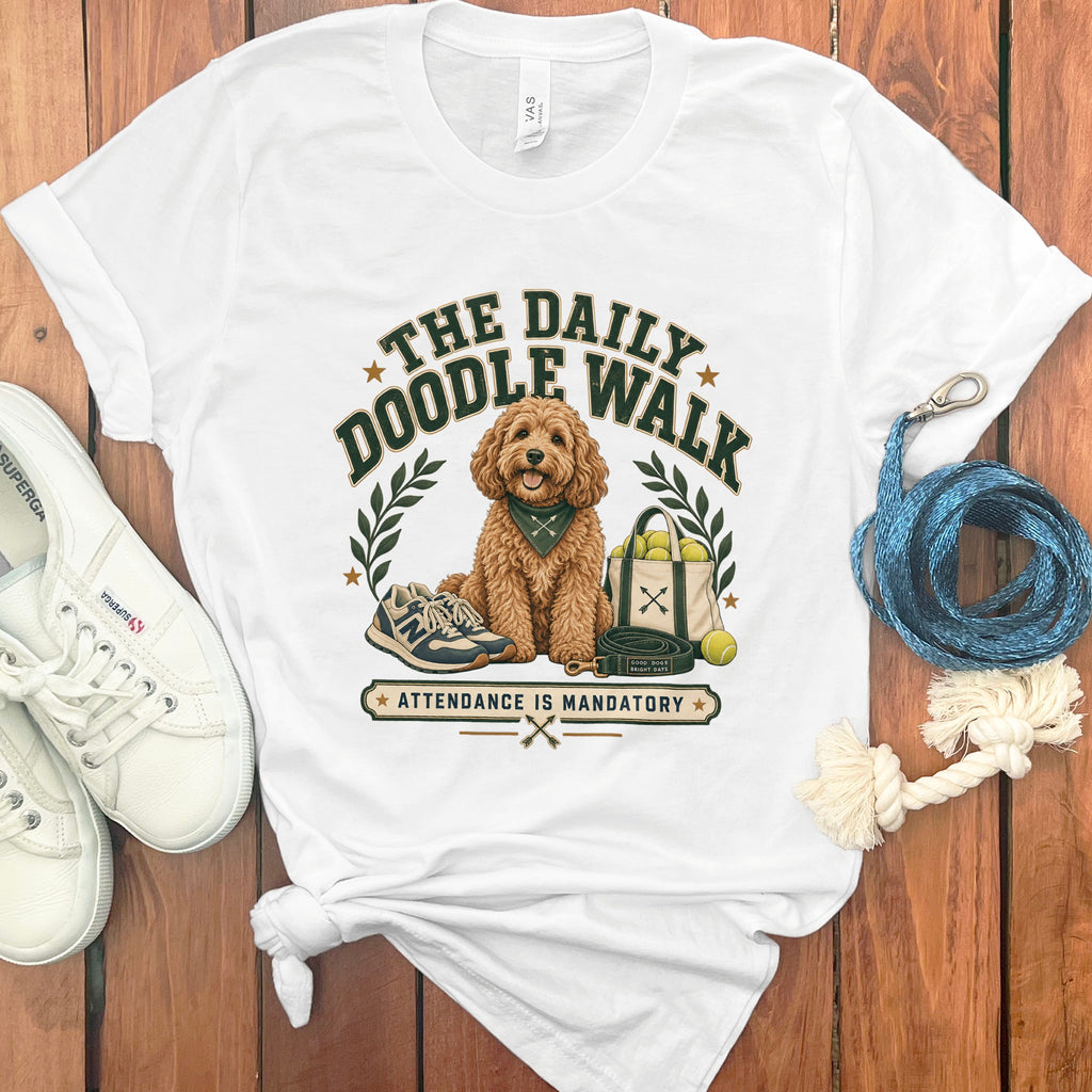 White t-shirt with a gold doodle dog graphic: "The Daily Doodle Walk".