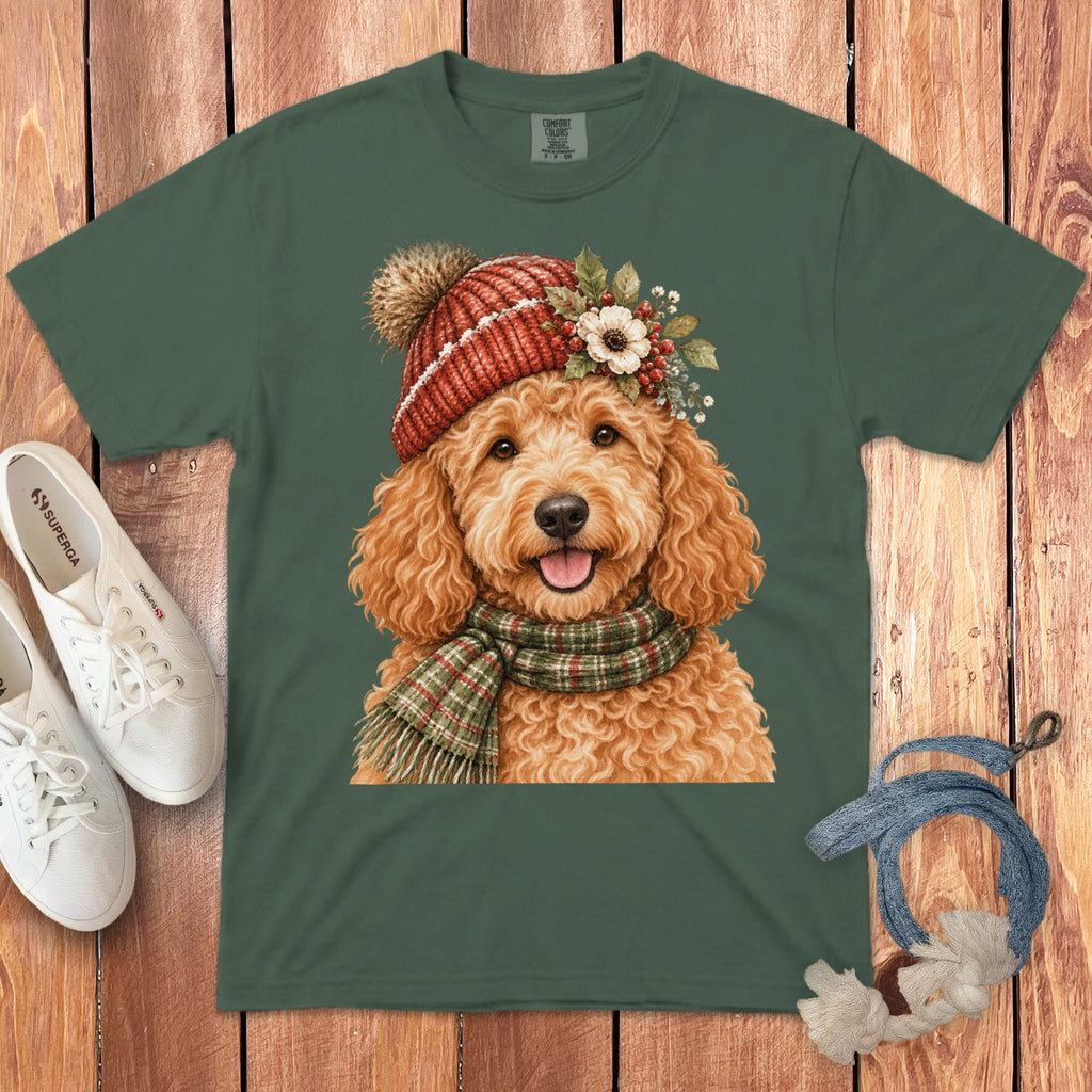 Green t-shirt with a watercolor print of a goldendoodle wearing a red knit hat and scarf.