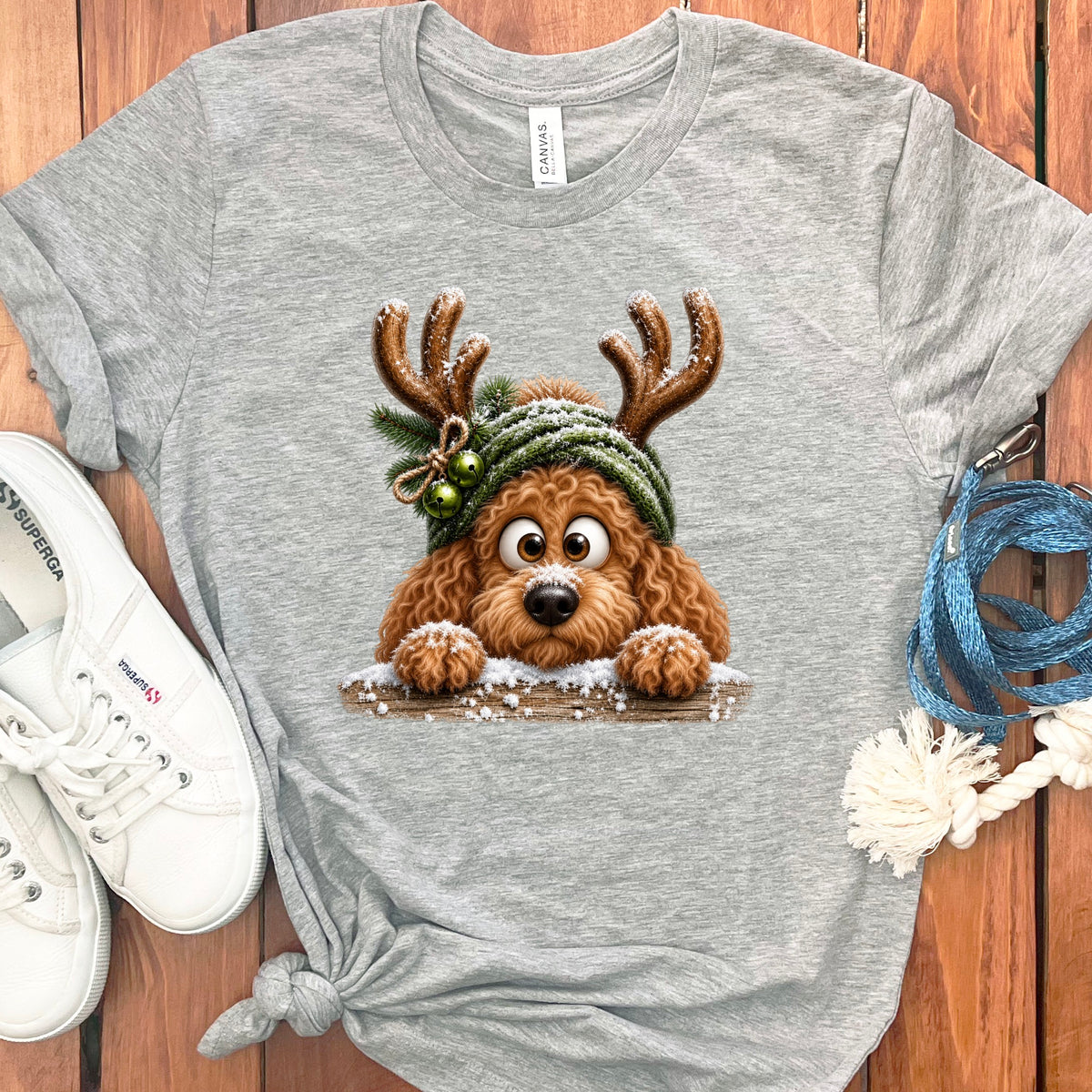 Gray t-shirt with fluffy dog wearing reindeer antlers and a green hat.