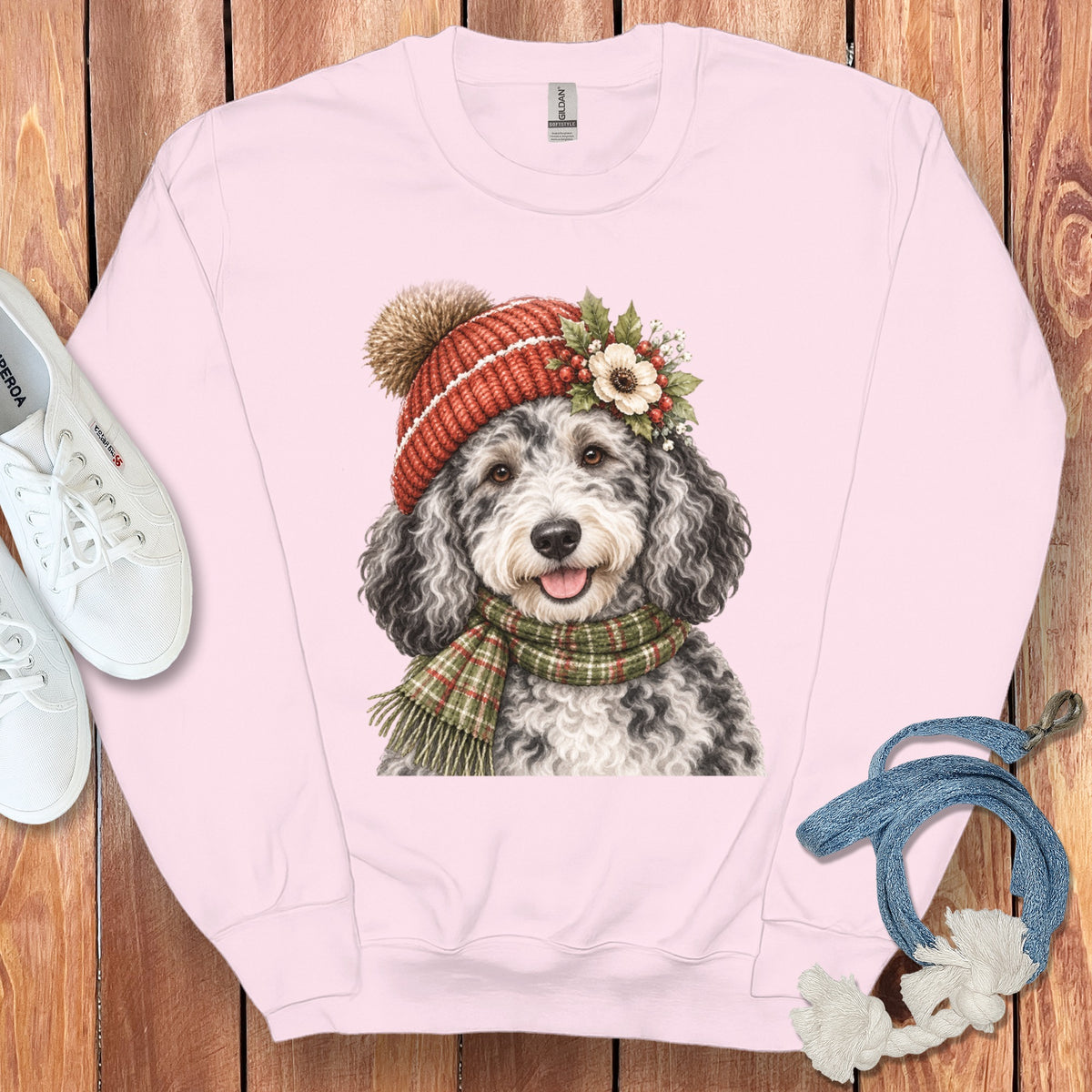 Pink sweatshirt with a watercolor print of a dog wearing a winter hat and scarf.