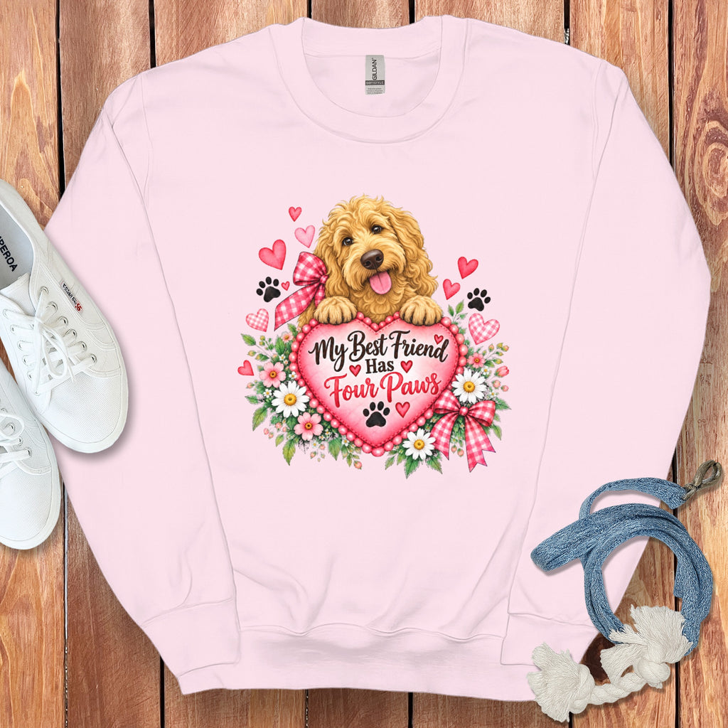 Light pink crewneck sweatshirt featuring a graphic of a golden doodle puppy behind a heart with text reading My Best Friend Has Four Paws.