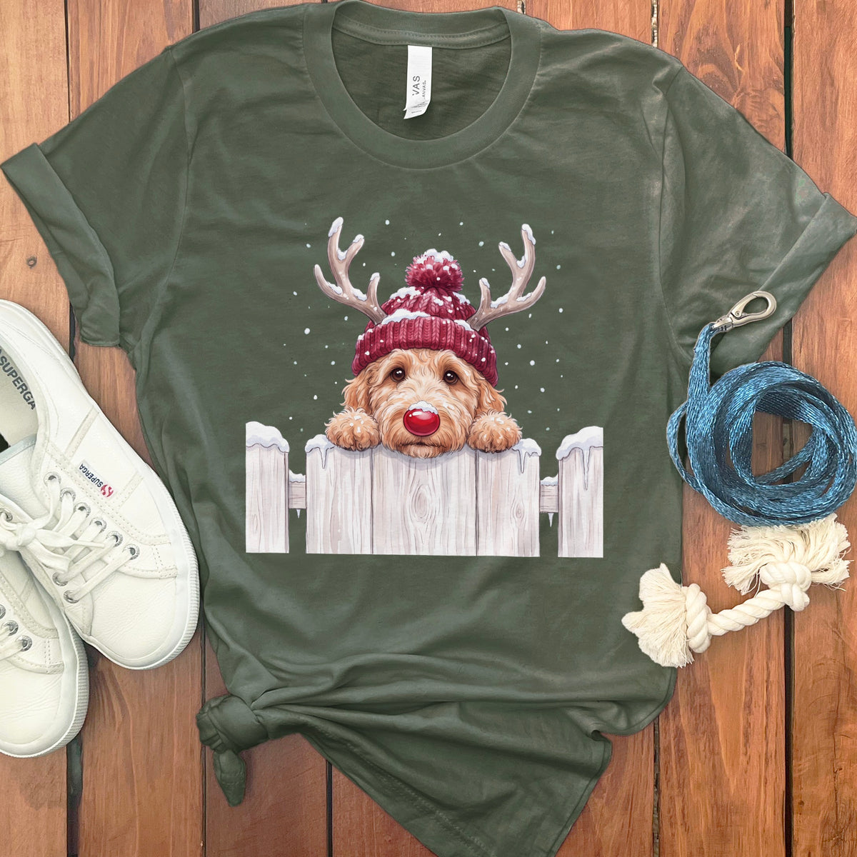 Green t-shirt with a doodle dog wearing a beanie and reindeer antlers.