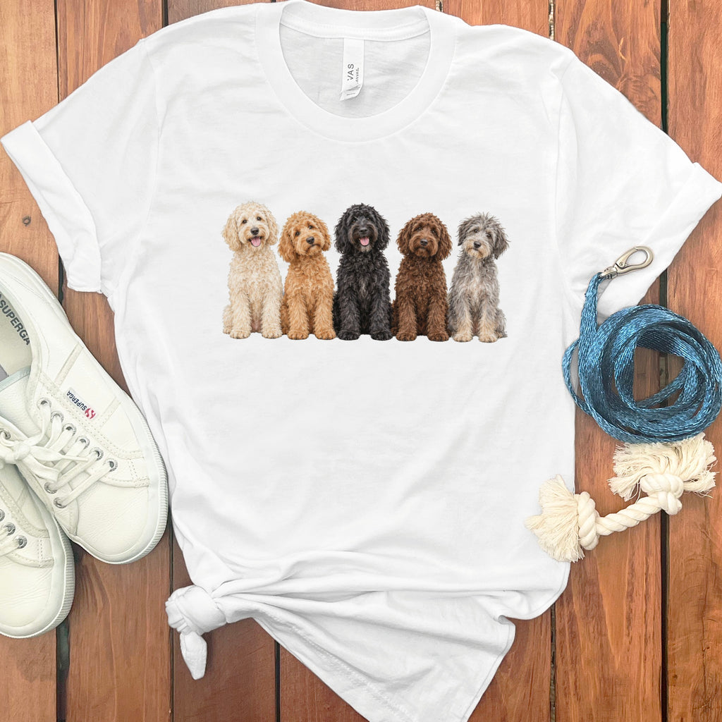 White t-shirt with a watercolor illustration of five fluffy dogs in a row.