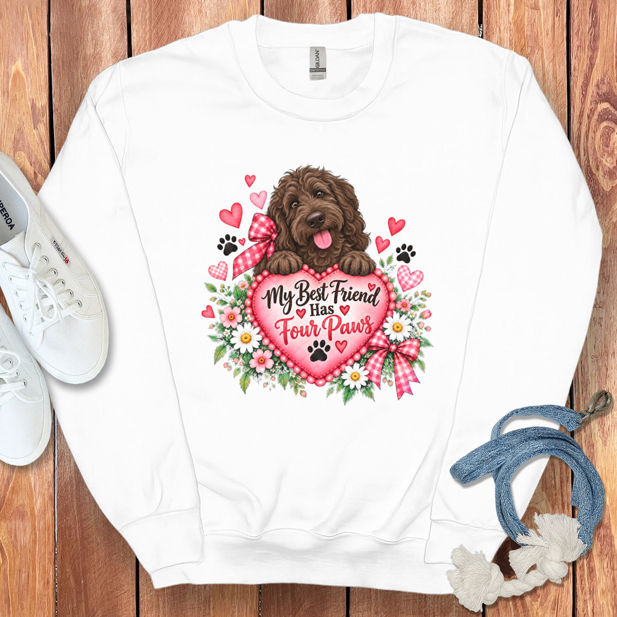 White crewneck sweatshirt with a graphic of a brown doodle dog resting paws on a heart that reads My Best Friend Has Four Paws surrounded by flowers, hearts, and paw prints.