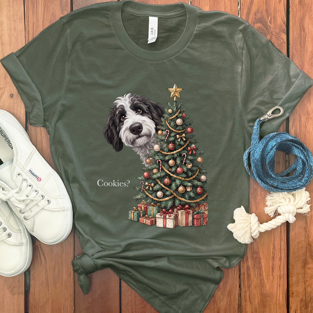 Dog peeking from behind a Christmas tree asking "Cookies?"