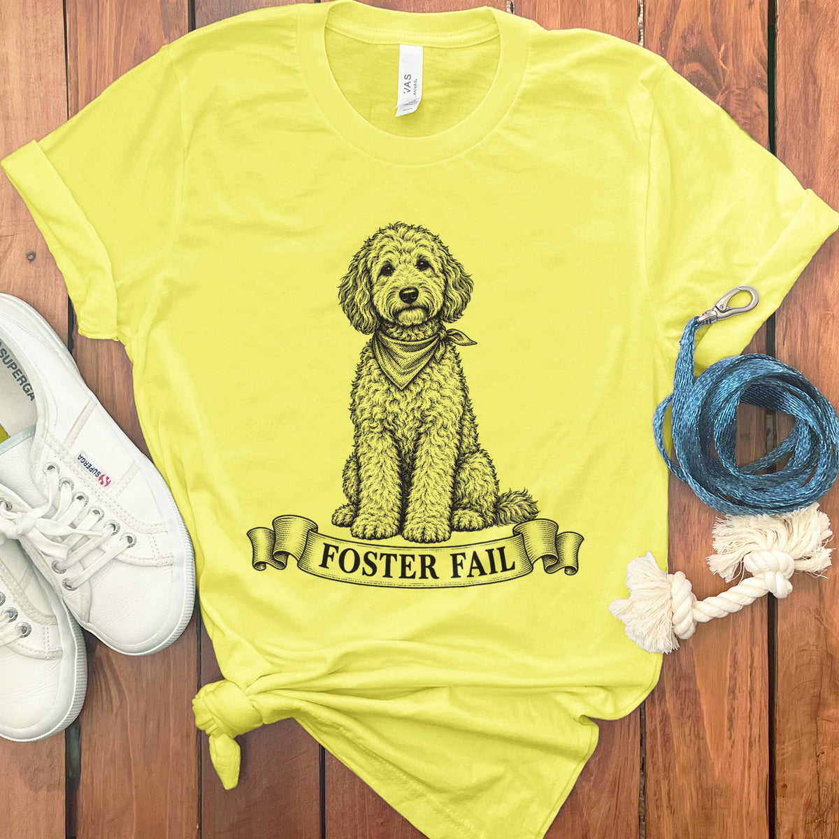 Yellow t-shirt with a doodle dog illustration and the text "FOSTER FAIL" on a banner.